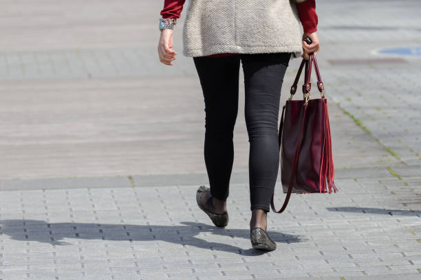 istock woman walking down the street with a bag 1081556446