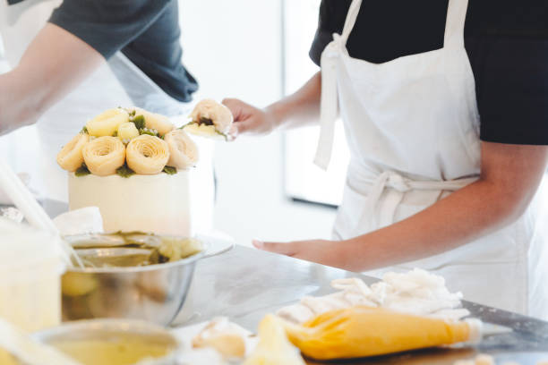 istock Pastry chef making a yellow butter flower for cake decoration. 1081561434