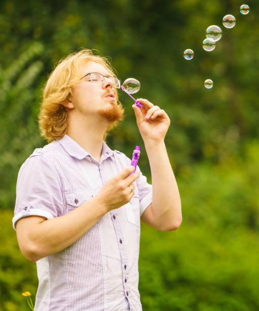 istock Man blowing soap bubbles outdoor 1081563554