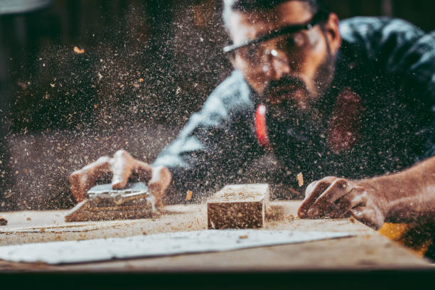 Young handosme carpenter Young handosme carpenter. Shallow DOF. Developed from RAW; retouched with special care and attention; Small amount of grain added for best final impression. 16 bit Adobe RGB color profile. woodshop stock pictures, royalty-free photos & images