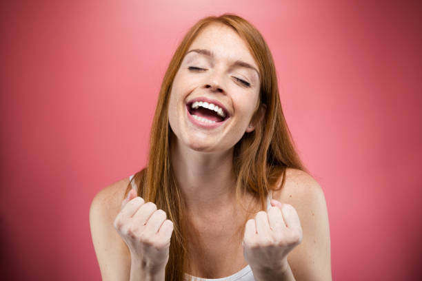 istock Euphoric young woman celebrating her successful over pink background. 1081563676