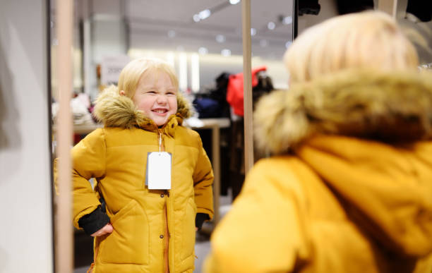 istock Cute little boy trying new coat during shopping 1081568092