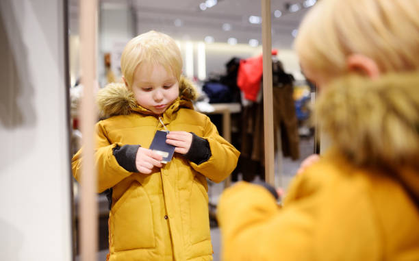 istock Cute little boy trying new coat during shopping 1081568108