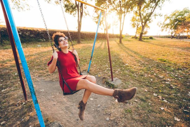 istock Young woman on a swing in a park 1081572266