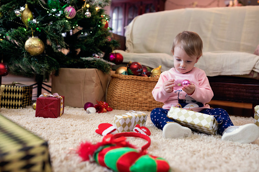Little baby girl playing with Christmas decoration