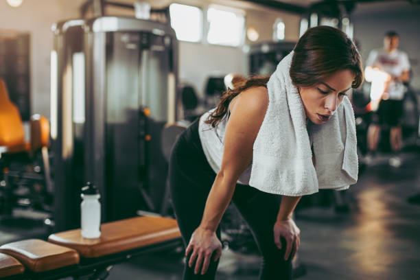 istock Young sportswoman lifting weights in gym 1081576450