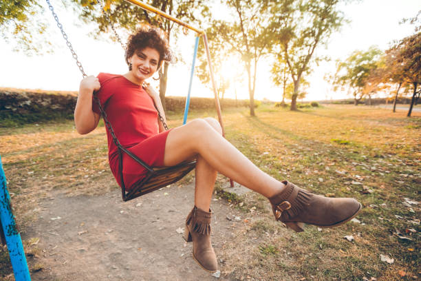 istock Young woman on a swing in a park 1081576688