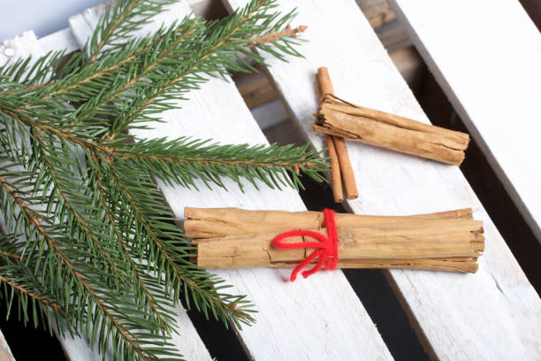 istock Cinnamon sticks next to the fir branches. On a wooden box. 1081579100
