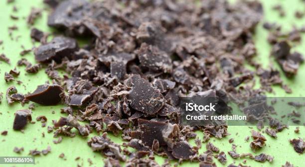 Dark Chocolate Crumbs On Green Background Stock Photo - Download Image Now - Black Color, Block Shape, Broken