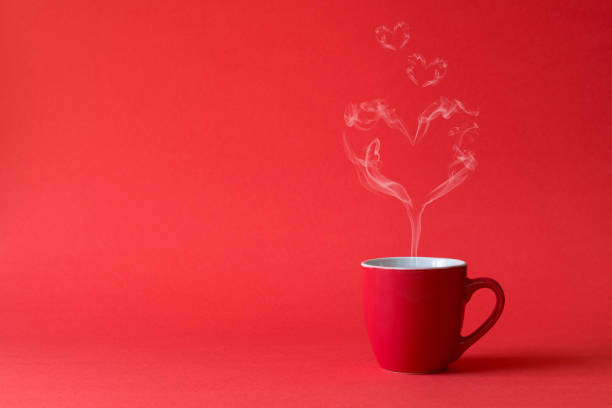 xícara de chá ou café com vapor em forma de um coração sobre fundo vermelho. conceito de celebração ou amor dia dos namorados. espaço de cópia - coffee color - fotografias e filmes do acervo