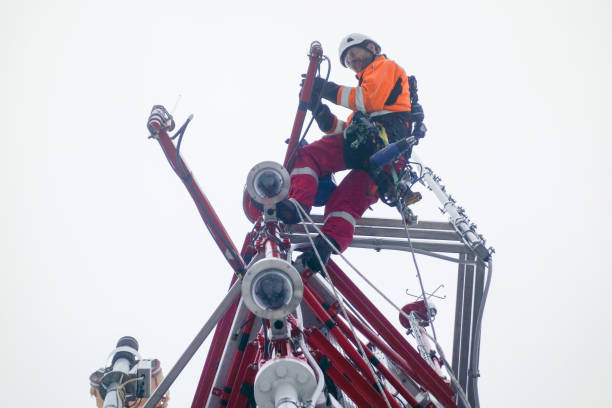 Rope access technician - electrician - working on top of the tower - antenna and doing inspection stock photo