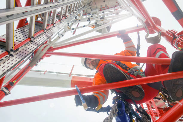 istock Charismatic Rope access technician climbing on the tower - antenna with hooks and looking down 1081591114