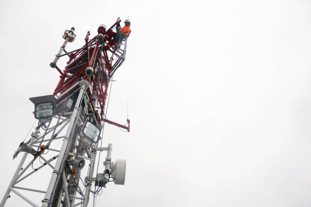 Rope access technician working on top of the tower - antenna
