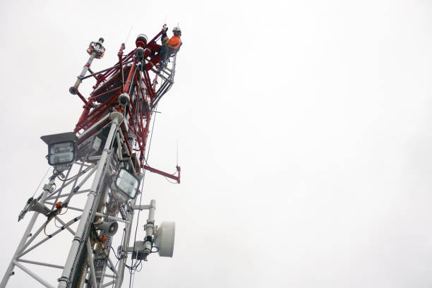 Rope access technician working on top of the tower - antenna stock photo