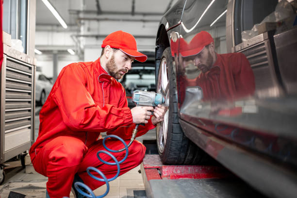 ar service worker changing wheel - car tire red new imagens e fotografias de stock