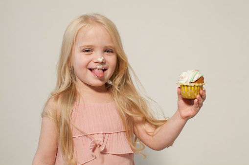 beautiful little girl blonde with cake and candy portrait