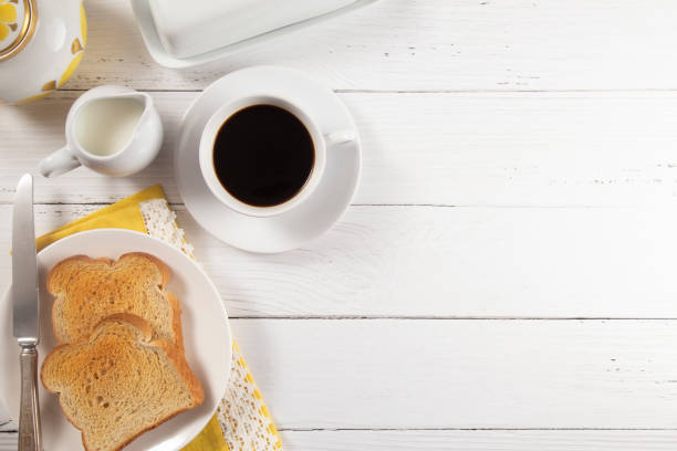 朝食にはトーストと白い木製テーブルでホット コーヒー - butter toast bread breakfast ストックフォトと画像