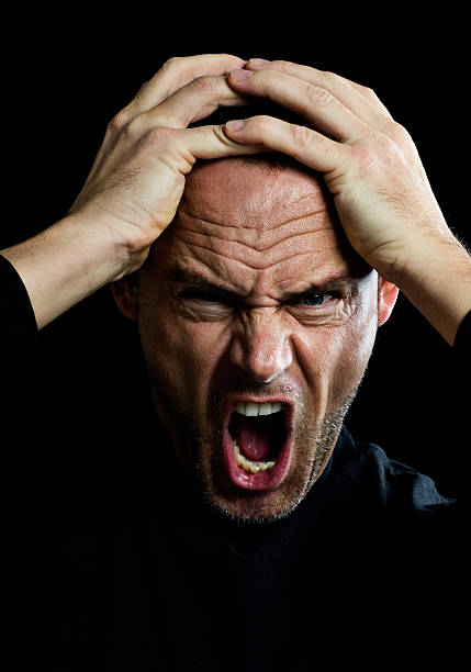 Man Yelling and Holding Head stock photo