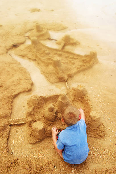 istock Little Boy Building Sandcastles on Beach 108161475