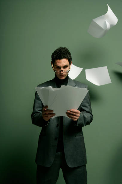 istock Businessman Reading Papers with Paper Flying Around Him 108161501