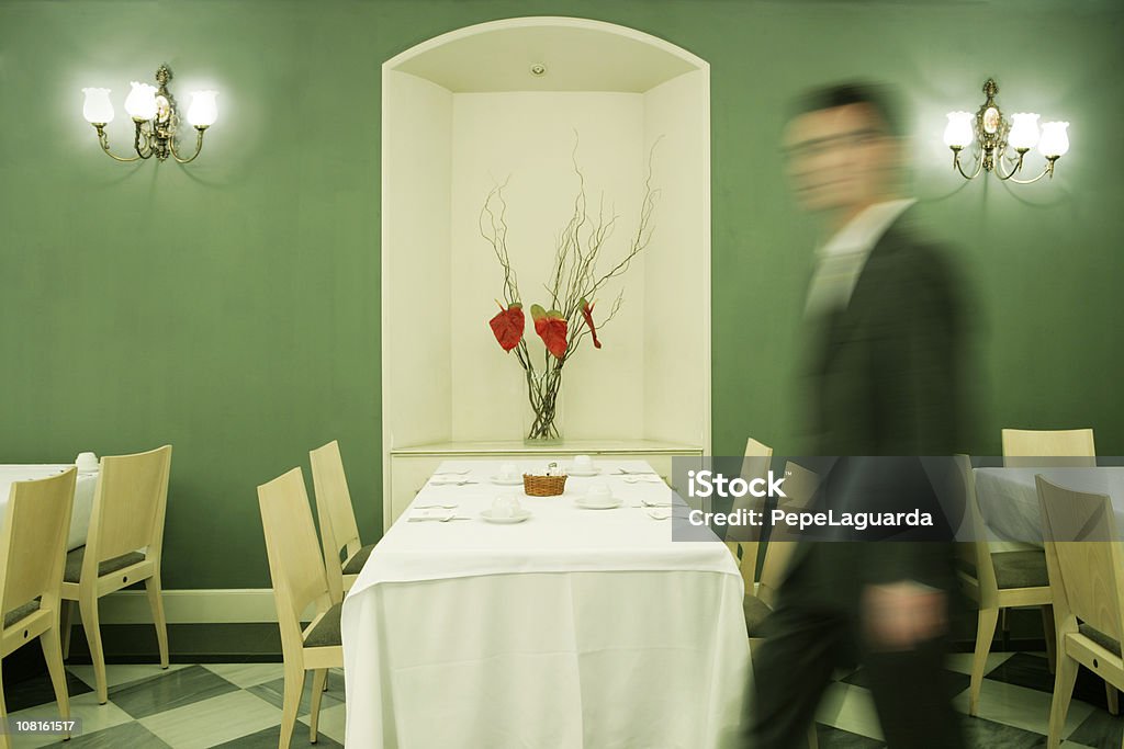 Desenfoque de hombre de negocios caminando dentro del restaurante - Foto de stock de Cubierto completo libre de derechos