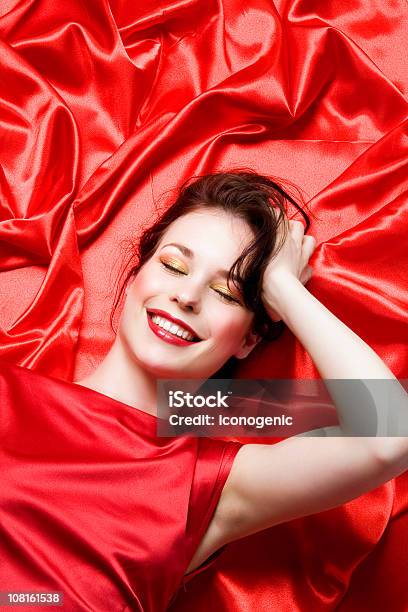 若い女性に横たわるレッドのシーツ - サテンのストックフォトや画像を多数ご用意 - サテン, 女性一人, 赤