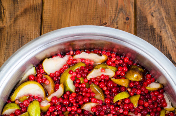 Closeup of a dark bowl filled with vibrant red pickled peppers, showing their appealing colour and texture.