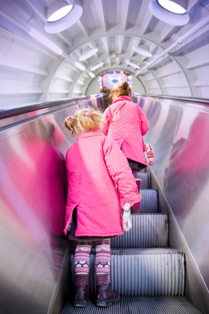 duas meninas andar e escadas rolantes - escalator child shopping mall little girls - fotografias e filmes do acervo