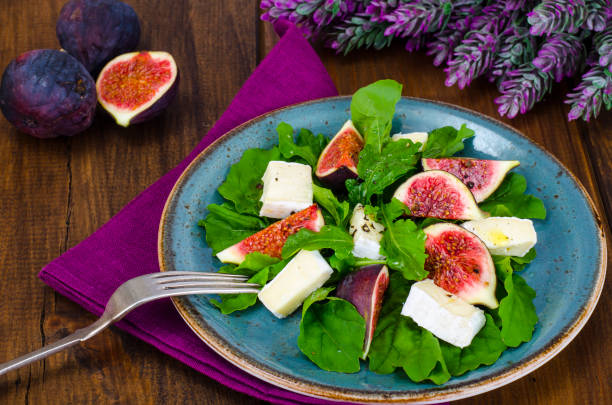Salad with figs, arugula and cheese brie. Studio Photo
