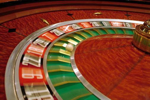 Casino roulette is on green gaming table with Georgian banknotes lari, poker chips.