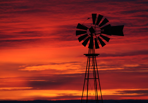 An isolated windmill with a sunset backdrop sits atop a hill in Brill, England