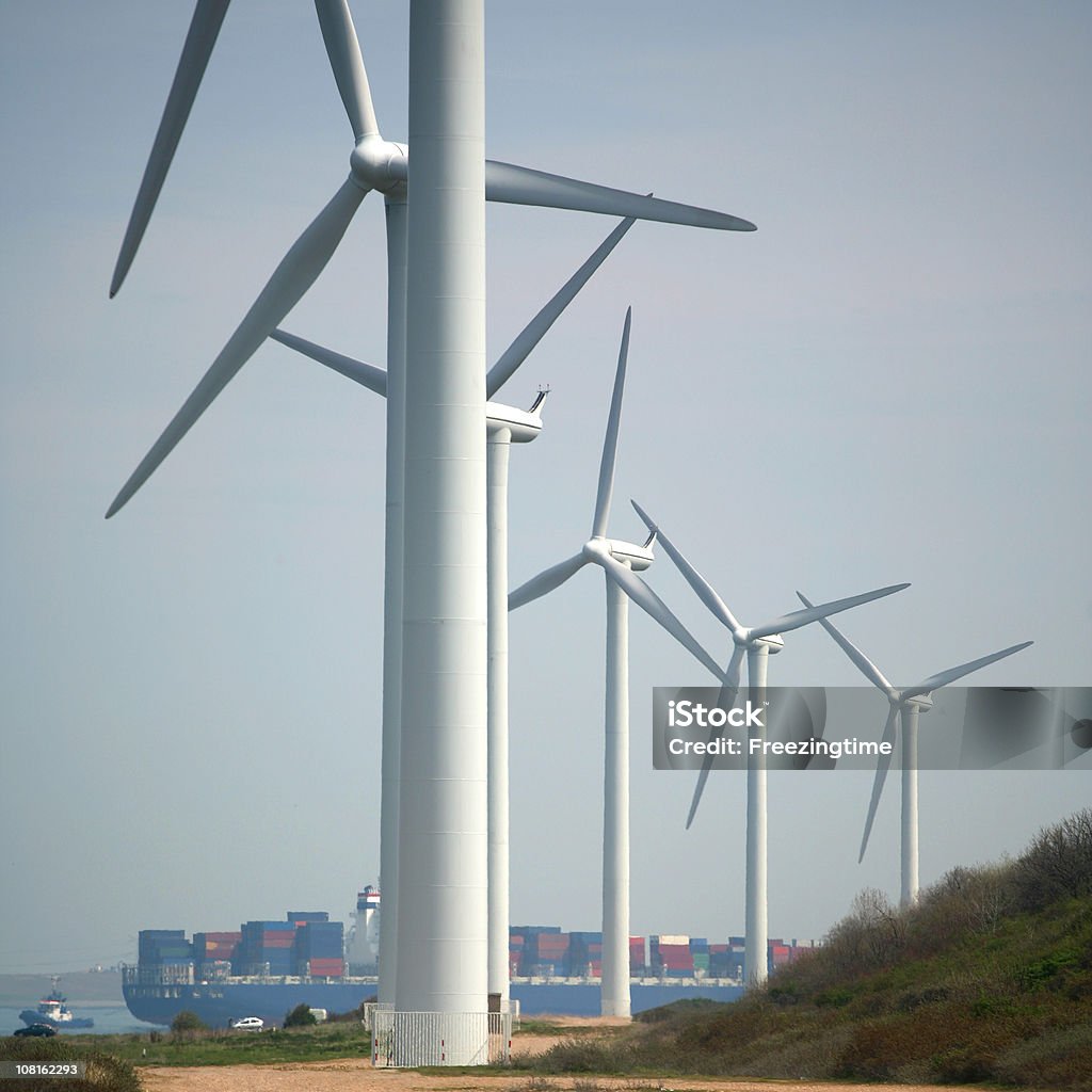Windmills with container ship in a harbor  Wind Turbine Stock Photo