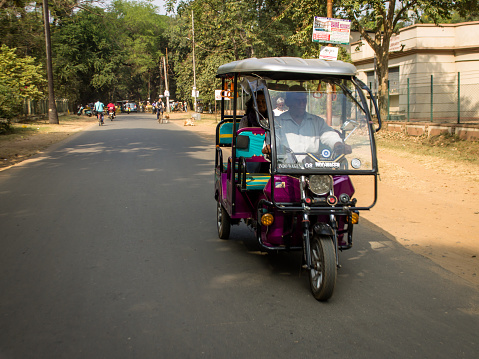 Bolpur, West Bengal ,India - November 30, 2018: An electric-powered rickshaw parked in a market in Bolpur in India. These motorized rickshaws are providing an alternative to human-powered cycle rickshaws for transportation in many parts of India.