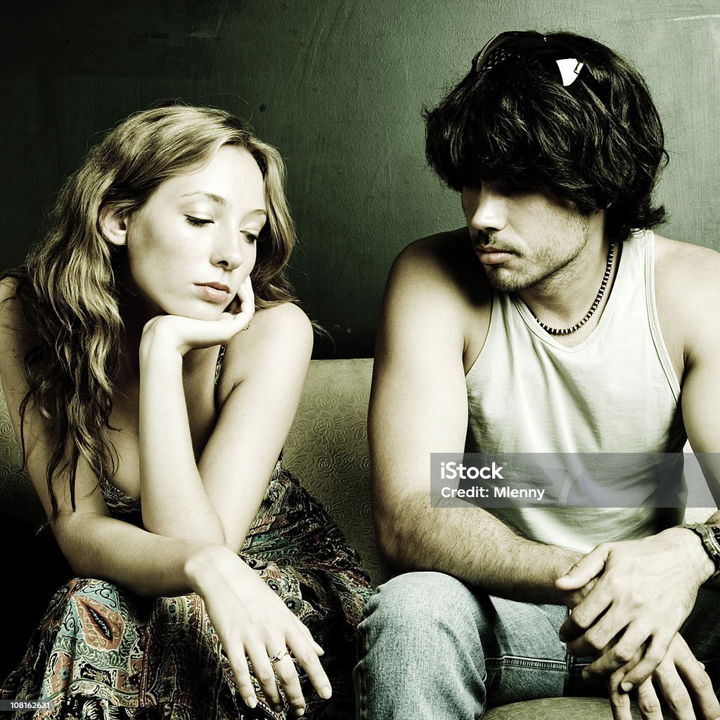 Sullen Couple Sitting on Couch  Sadness Stock Photo