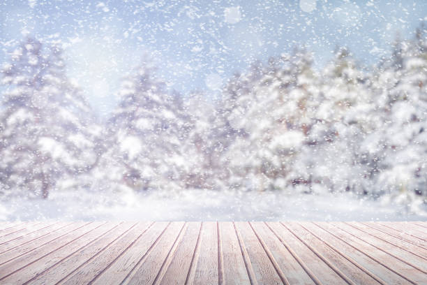 istock View on a brown wooden table against a winter forest in blur and snowfall (background, abstract, concept, copy space) 1081629190