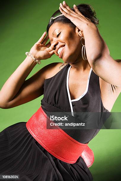 Młoda Kobieta Na Sobie Czarną Sukienkę I Taniec Na Zielonym Tle - zdjęcia stockowe i więcej obrazów Afroamerykanin