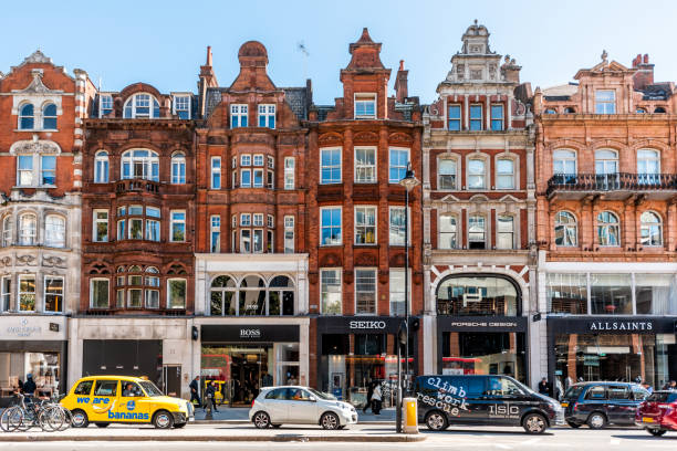 Neighborhood district of Knightsbridge brick architecture, road, cars in street traffic on sunny day London, UK - September 13, 2018: Neighborhood district of Knightsbridge brick architecture, road, cars in street traffic on sunny day harrods photos stock pictures, royalty-free photos & images