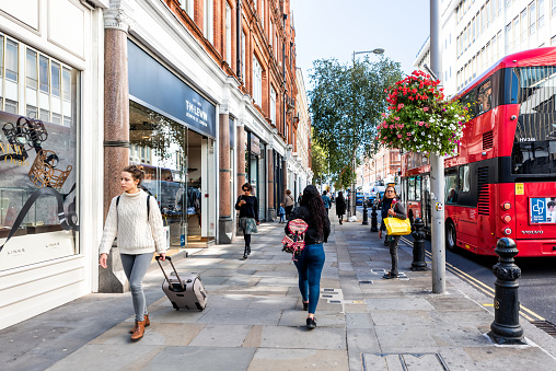 London, UK - September 13, 2018: Neighborhood district of Chelsea, street, red double decker bus, TM Lewin retail store, people walking on sidewalk