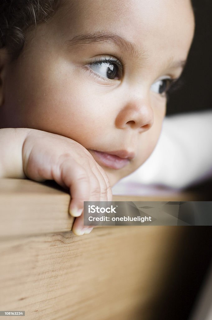 Bebê Menina com Mão no Queixo olhando para fora da janela - Foto de stock de 6-11 meses royalty-free