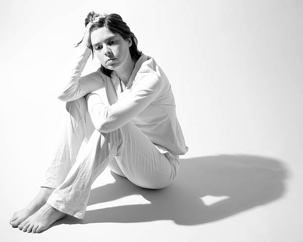 istock Depressed Young Woman Sitting on Floor, Black and White 108163236