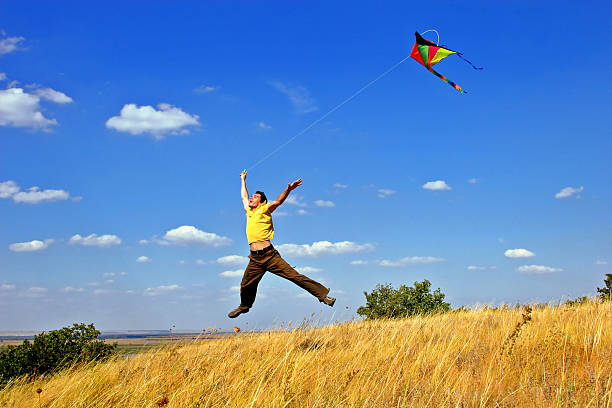 Cтоковое фото Молодой человек, прыгать в поле с Кайт