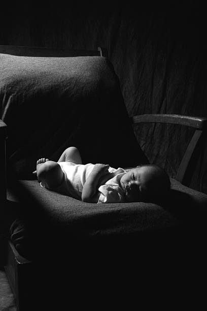 Lonely Newborn Baby Lying in Old Chair stock photo