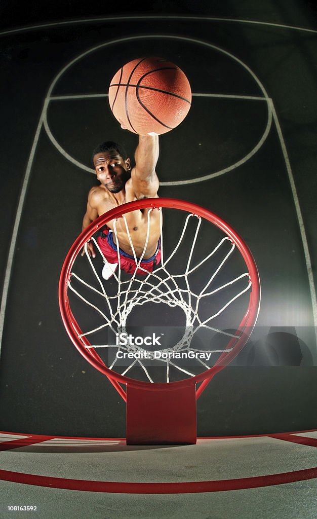 Giocatore di basket maschile salto sul campo di Dunk - Foto stock royalty-free di Giocatore di basket