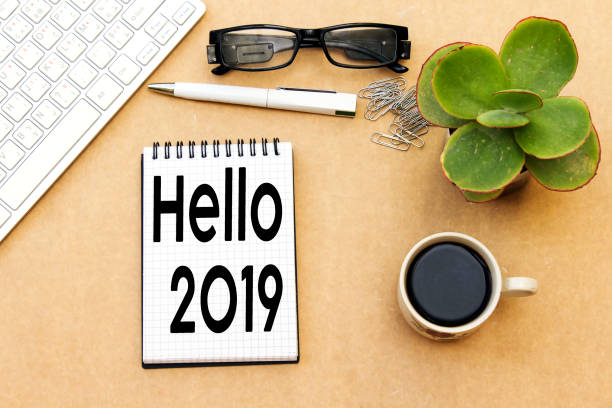 istock hello 2019, new year concept, desktop: notebook and cup coffee, pen, eyeglasses, keyboard ... 1081640396