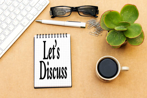 istock let's discuss concept, desktop: notebook and cup coffee, pen, eyeglasses, keyboard ... 1081642004