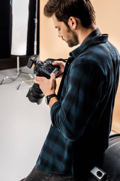 istock handsome young photographer using camera in photo studio 1081643990