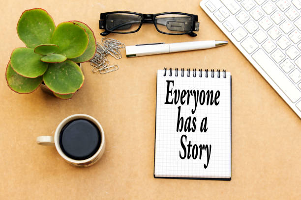 istock everyone has a story concept, desktop: notebook and cup coffee, pen, eyeglasses, keyboard ... 1081644940