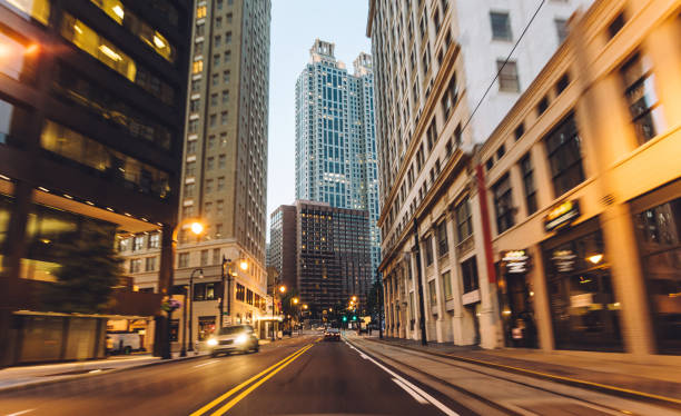 viajando a través de la ciudad al atardecer - urban road fotografías e imágenes de stock