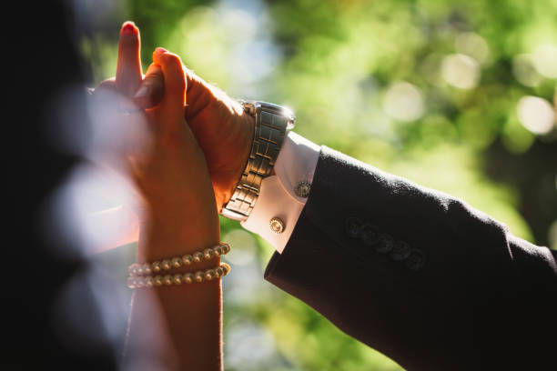 istock hands bride and groom on blurred background 1081652420