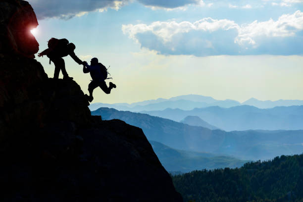 istock Man is giving helping hand & Alpiniste escalade 1081652894